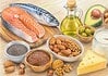 Vetten, cholesterol en gezondheid Onverzadigde vetten uit vis, noten en olijfolie naast producten met verzadigd vet op een houten tafel